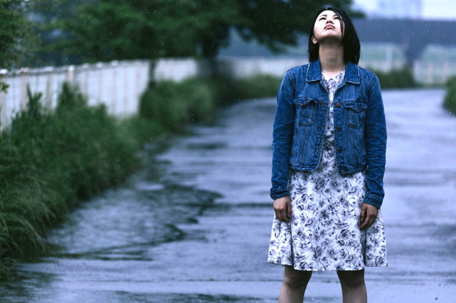 Girl standing in the summer rain.